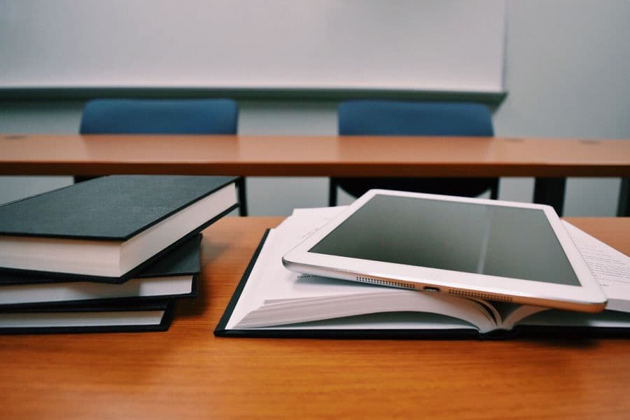 Books and a tablet on a classroom desk